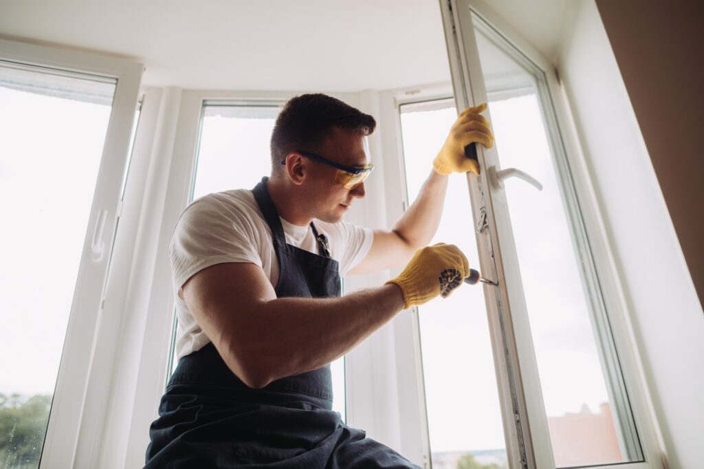 Maintenance man fixing windows with instruments