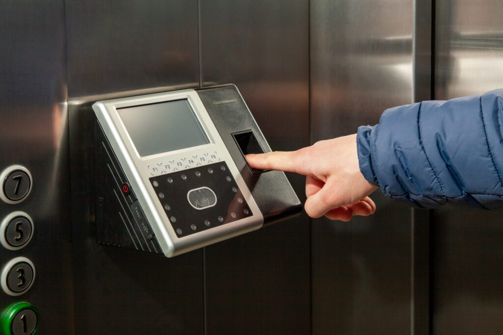 Man put finger in Fingerprint Access Control Terminal installed in elevator